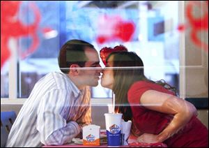 Rich Curry puckers up for his girlfriend, Laura Brown, as the West Toledo couple enjoy a special Valentine's Day meal at the White Castle near downtown Toledo. 'It's very special to us,' Ms. Brown said, adding: 'I think this might become a tradition.' 