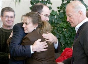 Michael Dressel, father of slain detective Keith Dressel, looks on as Danielle Dressel, the officer's widow, gets a hug from Police Chief Mike Navarre. Mayor Carty Finkbeiner is at right.