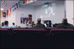 Firefighters and police offi cers watch the funeral on a church TV screen. Toledo s four television
stations broadcast the funeral, but two ended coverage early because of technical problems.