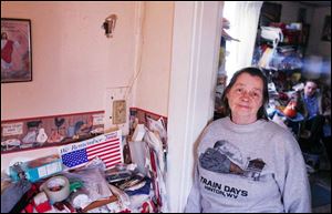 Eula Bennett, 73, stands by a hole in her home's wall, believed to have been made after burglars shot inside her house.