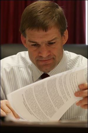 U.S. Rep. Jim Jordan examines documents during a break in meetings on Capitol Hill in Washington.