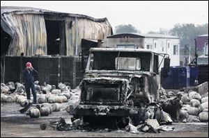 An investigator takes photos of the aftermath of an explosion and fire that struck Reliance Propane and Fuel Oil.