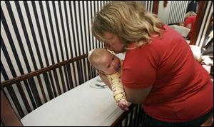 Mrs. Gokey kisses Abigail as he puts her to bed.