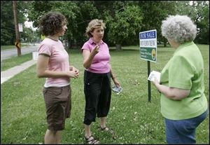 Elisa Roush, left, and her mother, Elinor, talk with city council candidate Karen Shanahan, who
opposes the city plan to sell the strip of land between River Road and the Maumee River.
