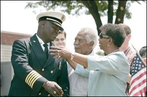 Former Fire Chief Mike Bell, now Ohio fire marshal, is congratulated by his father Norm and mother, Ora, as a street and the fire department headquarters are named in his honor.