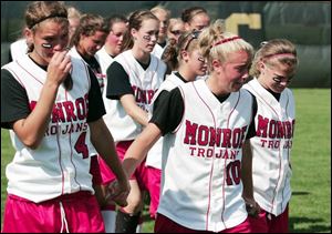 From left, Monroe's Katie Cooley, Amanda Straub and Amber Rafko hold hands after the loss.