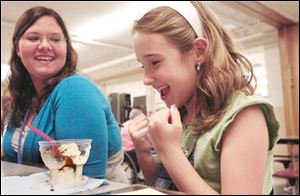  Katie Mills, left, a Harborside Health Care staff member, enjoys an ice cream treat with pen pal Katlyn Johns of Hill View Elementary School at the meeting of the students and their pen pals.