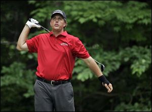 Phil Mickelson appears to be swinging with one arm. He said he was releasing his left hand early to avoid hurting his wrist. The sand flies as Tiger Woods hits out of the sand trap at the 
No. 8 hole during the opening round of the U.S. Open. Fred Funk hits onto the green at No. 8 in U.S. Open play at Oakmont yesterday. He also observed his 51st birthday.