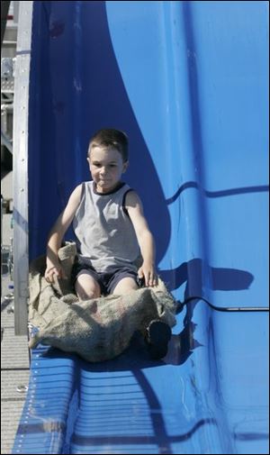 Roy Gruetter, 6, of Liberty Center plunges down the Fun Slide at the annual Holland Strawberry Festival. 