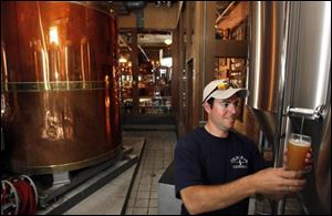 Brewmaster Phil Pollick takes a sample at the Maumee Bay Brewing Company on Broadway near downtown Toledo.