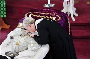 At St. George Bulgarian Orthodox Cathedral in Rossford, the Rev. Don Anthony Freude, chancellor of the Diocese of Akron, pays his respects to Archbishop Kyrill, who died Sunday. 