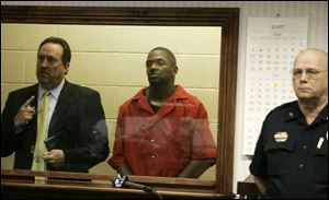 Attorney Bradley Iams, left, accompanies Bobby Cutts, Jr., a police officer in Canton, behind a glass window in court. Officer Cutts is accused of killing his pregnant girlfriend.