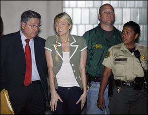 Escorted by lawyer Richard Hutton, left, and two sheriff s
deputies, Paris Hilton leaves jail in Lynwood, Calif.
