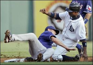 The Rangers  Michael Young can t stop the Tigers  Curtis Granderson from stealing second base in the first inning.
