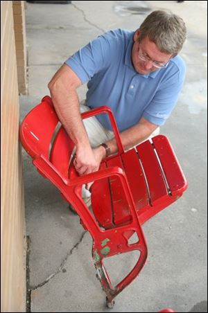 Paul Ringlein of the division of facility operations checks an arena chair. Fans can buy one for as little as $10 in cash.