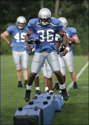 Detroit Lions running back Aveion Cason runs agility drills during the first day of camp in Allen Park, Mich.