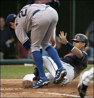 The Indians  Victor Martinez tries to score, but he is tagged out by Rangers pitcher Brandon McCarthy in the fourth inning.
