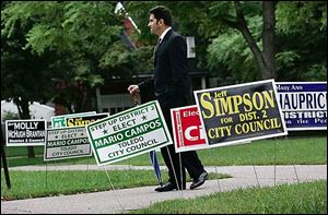 Toledo City Council candidate Mario Campos greets voters outside Beverly ElementarySchool.