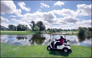 James Goda, assistant superintendent at Detwiler Park Golf Course, surveys a flooded green. The course has been closed for three days because of flooding caused by the failure of two pumps. Detwiler Ditch and Mud Creek overflowed their banks and submerged all of the course's foot bridges.