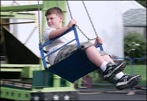 Zachary Schreiber, 11, of Grand Rapids takes a view of festival activities from a seat on one of the amusement rides.