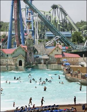 With roller coasters looming, patrons enjoy the wave pool at Geauga Lake.