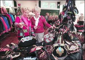 Suzanne Bond of Holland, from left, and Cindy Meloy of Perrysburg look over Vietnamese-made handbags. 