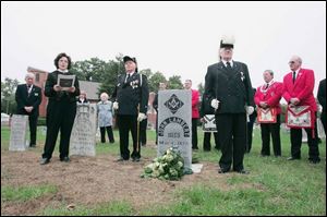 Trudy Urbani, left, talks during the ceremony in Lambertville Cemetery. Flanking the tombstone are Masons K. Lee Yeager, left, and Charles Mahoney, right, of the Samaria Lodge #438.