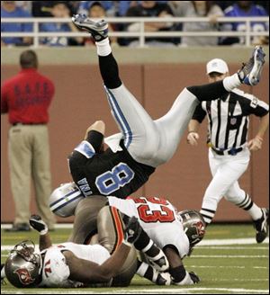 The Lions' Jon Kitna, a throwback quarterback, was upended by the Bucs defense but his scramble earned a first down.