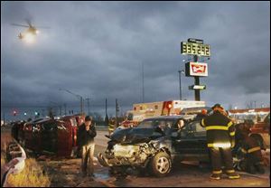 Emergency crews work at the scene of an accident on southbound I-280 as a medical helicopter approaches, at left. The crash was one of two locally that killed two people last night.