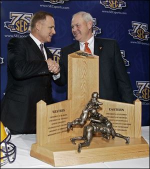 LSU coach Les Miles, left, and Tennessee coach Phillip Fulmer pose with the Southeastern
Conference football trophy. Their teams will meet this afternoon in the Georgia Dome.