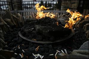 Outside Claddagh s at Westfield Franklin Park, cigarette butts litter a fire pit used to warm smokers.
