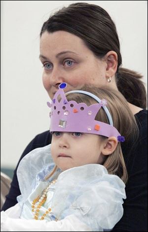 NBRN tea03 3 12/27/2007   BLADE PHOTO/Lori King    LaSalle, Mich. resident Madison Jacob, 3, is in full princess attire while listening to Monroe County queens speak during A Royal-Tea at Erie Branch library. She's sitting on her mom's (Peggy Jacob) lap.