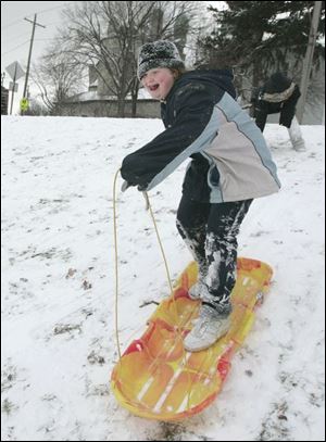 ROV snow02p 01/02/08 The Blade/Dave Zapotosky Nicole Canady, 12, slides down a snow covered hill near Waite High School, in Toledo, Ohio, on Wednesday, January 2, 2008.  She and several friends were taking advantage of a fresh snowfall and a day off from school.