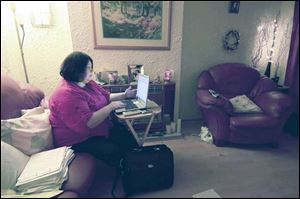 Karen Torley, 41, does casework on her laptop as she watches television and takes phone calls in her home in Glasgow. Ms. Torley began the campaign to free inmate Kenneth Richey.