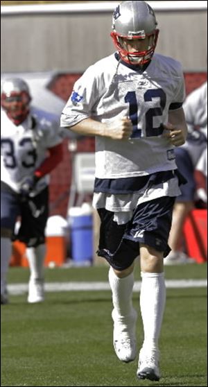 With his right ankle taped, New England Patriots quarterback Tom Brady (12) runs before practice began at Sun Devil Stadium in Tempe, Ariz. on Monday. The Patriots will play the New York Giants in Super Bowl XLII in Glendale, Ariz., on Sunday. 