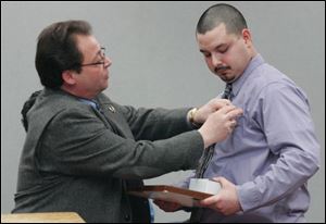 Clerk of Courts Bernie Quilter puts a Lucas County lapel pin on Jacob Lopez, the Taco Bell employee who notified police about a drunken driver who was later in a fatal crash on I-280. (THE BLADE/LORI KING)
<br>
<img src=http://www.toledoblade.com/graphics/icons/photo.gif> <b><font color=red>VIEW</b></font color=red>: <a href=