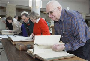 Gene Gilsdorf of Lake Township, right, leafs through a tax record book from Perrysburg Township dated from 1840. Behind him, Barbara Harbauer of Perrysburg Township and Fred Witzler of Luckey, Ohio, comb through property taxes from 1861. The members of the Wood County Chapter of the Ohio Genealogical Society toured the Wood County Courthouse in their quest to find their ancestry. 