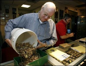 Clyde Englehardt pours out a bucket of scrap gold sold to his Toledo Coin Exchange. 