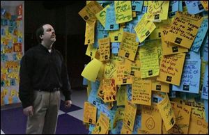 COSI's director of exhibits, Carl Nelson, reads the 'memory wall' only a little bit at a time because it saddens him. 