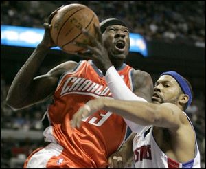 Charlotte's Jason Richardson, left, grimaces as he drives against Detroit's Rasheed Wallace.