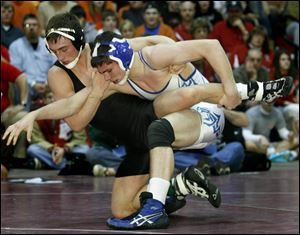 Delta's Derrick Yant, left, and Tiffin Calvert foe Kyle Kwiat battle for a takedown during their 160-poung match at the Division III district tournament at Owens Community College.