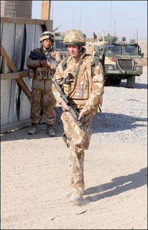 In this image made available in London, Thursday, Britain's Prince Harry leaves a Forward Operating Base on his way to patrol through the deserted town of Garmisir, Afghanistan, on Wednesday Jan. 2, 2008.