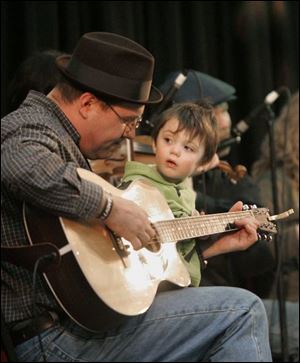 Ryan Koop, 2, joins his dad Martin Koop, both of Tiffin, on stage as he performs traditional Irish music during the 18th annual Lucas County Hibernian St. Patrick's Day Festival.