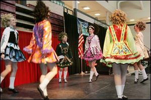 Emily Kerr, left, and Gabby Trojanowski, center, perform with other dancers from the Heinzman School of Irish Dance. Joe Rawlins of Toledo finds it's not easy going green as he gets ready for the festival.