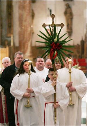 Aidan Dillon, 12, of Sylvania leads the processional after a Palm Sunday service at Our Lady of the Most Holy Rosary Cathedral in Toledo. Today is the start of Holy Week.