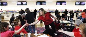 Judy Lou of the Northwood Jewelers team from Toledo gets high fives from her teammates at Interstate Lanes in Rossford.