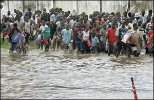 Tanzanians walk through a flooded street as they try to follow the procession of the Olympic torch through Dar Es Salaam, Tanzania on Sunday. (ASSOCIATED PRESS)
<br>
<img src=http://www.toledoblade.com/graphics/icons/video.gif> <b><font color=red>AP VIDEO</b></font color=red>: <a href=