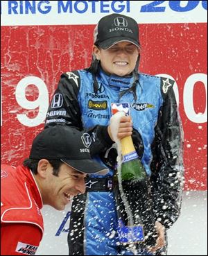 American Danica Patrick of Andretti Green Racing sprays champagne with second-place Brazil's Helio Castroneves of Team Penske on the podium after winning the Indy Japan 300 auto racing at Twin Ring Motegi in Motegi, northeast of Tokyo on Sunday. 