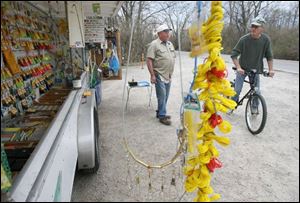 Dennis Bryant, at left, the owner of ZAP Custom Lure Co., chats with Thomas Fisher about the lures, lines, and bait on sale. 