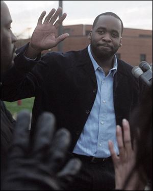 Detroit Mayor Kwame Kilpatrick waves to well-wishers while talking to the media during a news conference after a speaking engagement at Samaritan Center on Tuesday in Detroit. Kilpatrick made a brief statement regarding the release of a document containing text messages showing a romantic relationship between himself and his former chief of staff Christine Beatty. 